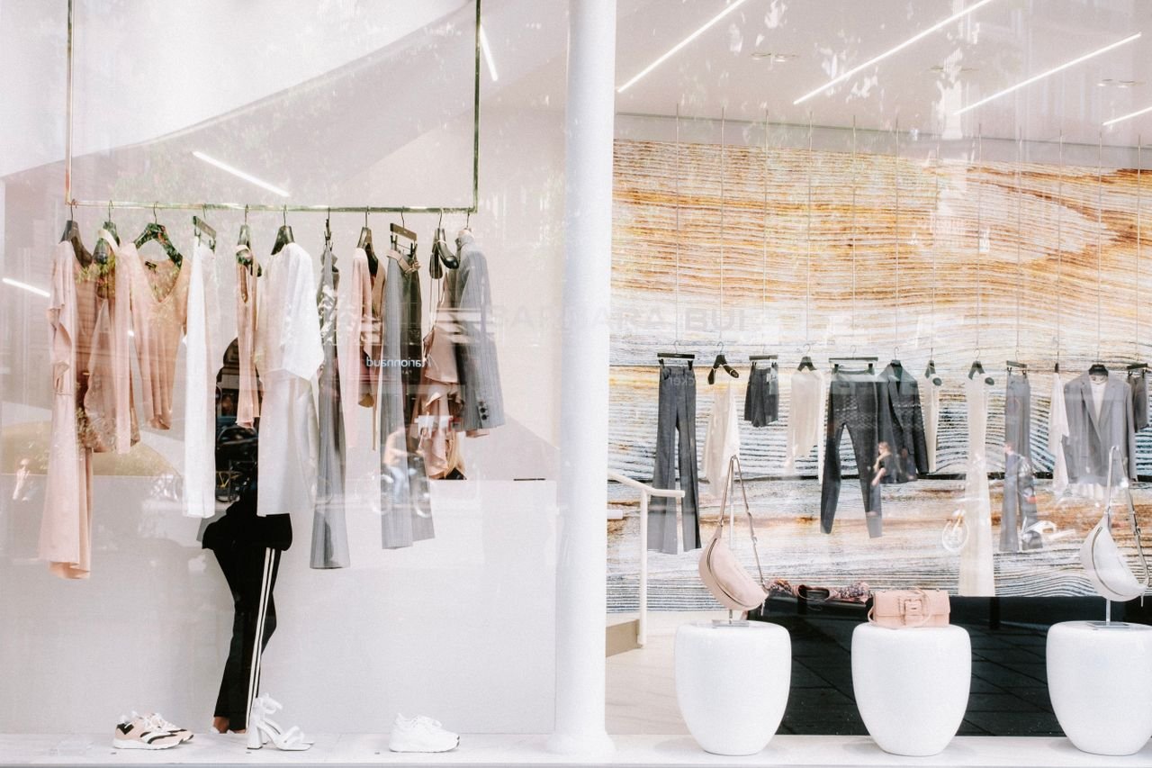 Chic fashion display at a clothing store with stylish reflections.