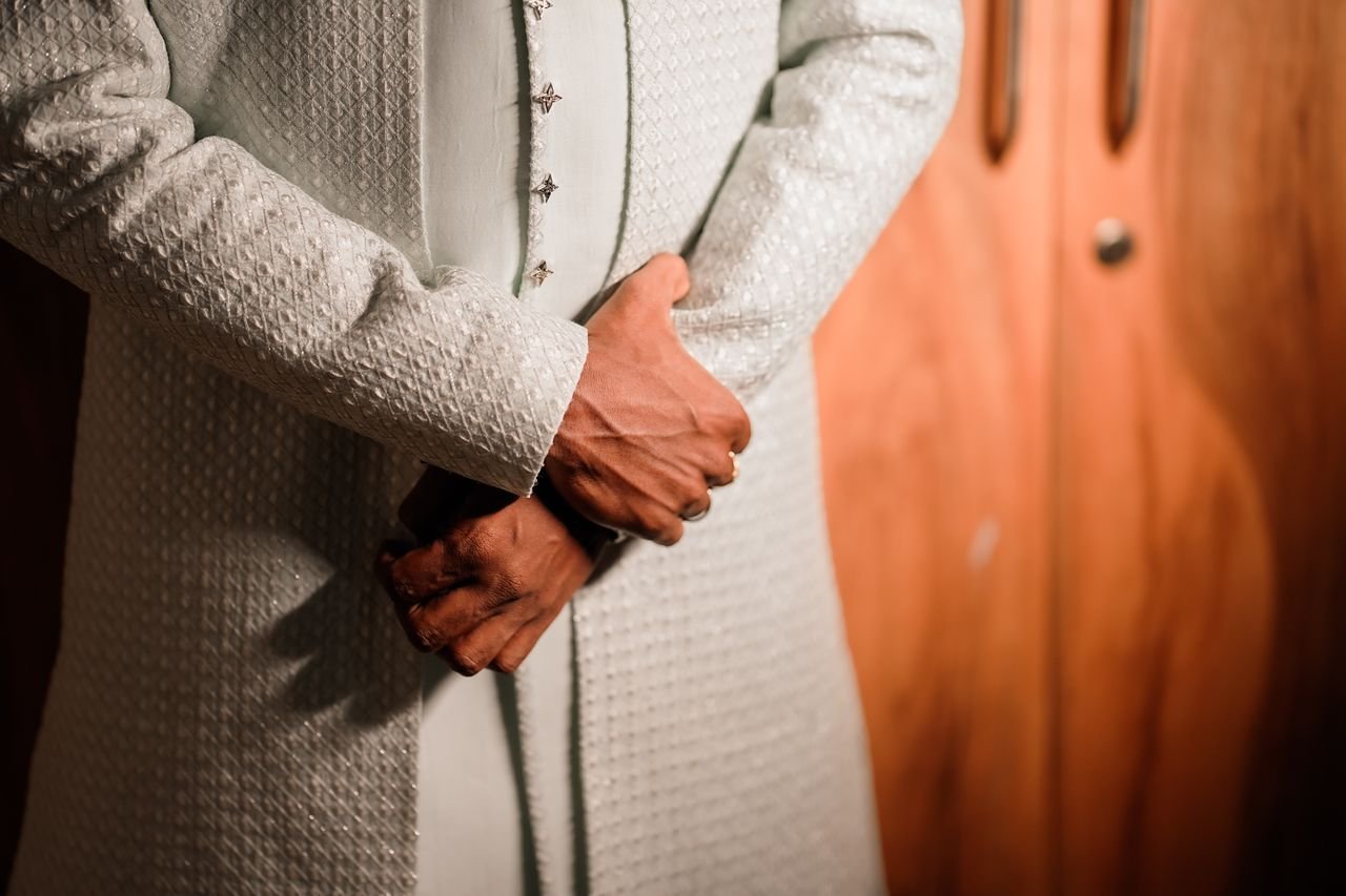 Close-up of a man in an embroidered sherwani, showcasing elegant traditional Indian fashion.